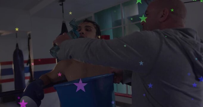 In boxing ring coach lifting bottle pouring water boxer holding blue-bucket cooling stars showing