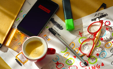 Calendar with business appointments and deadlines,pens,coffee cup smartphone and paperwork on ...