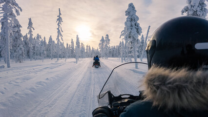 Naklejka premium Thrilling snowmobile adventure through the winter wonderland of Akaslompolo, Lapland, Finland