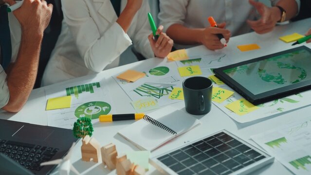 Close up of business people hands write notes about sustainable energy and environmental idea. Group of diverse people taking a note and brainstorming about green tech. Focus on hand. Alimentation.