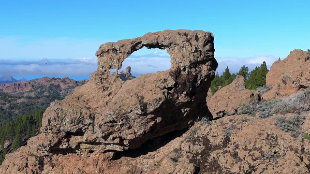 Amazing view from the Ventana del Nublo, a natural rock arch, showing the iconic Roque Nublo and Teide volcano in the distance