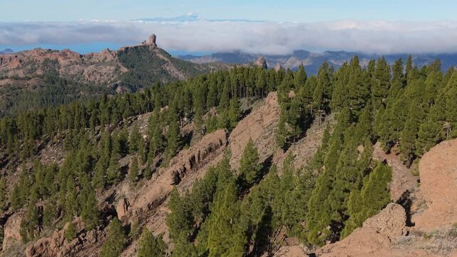 Stunning aerial view revealing the iconic Roque Nublo and Teide volcano from behind the Ganifa arch in Gran Canaria, Canary Islands
