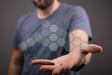 Hand holding a futuristic digital network with hexagonal cells, symbolizing connection, data and...