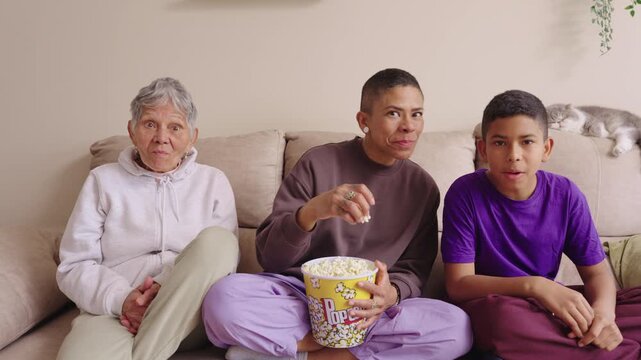 Multi generational latin family watching an exciting movie at home