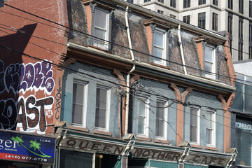 Naklejka premium exterior building facade and sign of Queen Mother Cafe, a restaurant, located at 208 Queen St W, Toronto