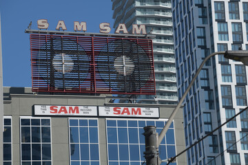 Naklejka premium 1969 vintage restored neon signs of Sam the Record Man signs originally on the front of 347 Yonge St, now facing Sankofa Square, Toronto