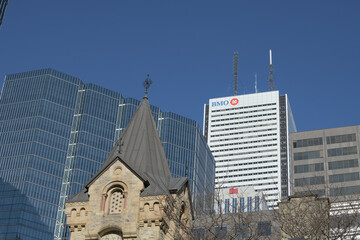 Naklejka premium contrast of architectural styles and eras: foreground stone tower of St. Andrew’s Presbyterian and office towers in the Financial District (looking east from King and Simcoe), Toronto