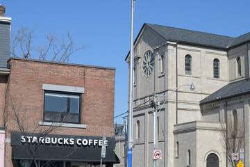 Naklejka premium exterior building facade and sign of Starbucks Coffee Company located here at 604 Danforth Av, corner of Gough Av (next to Holy Name Parish), Toronto