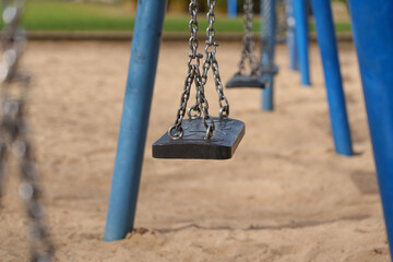 Closeup of empty swing seat and chains in modern playground in D&uuml;sseldorf, Germany