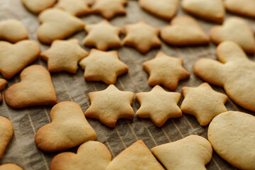 Close-up of freshly baked Christmas cookies in various shapes: hearts and stars. Perfect for holiday season or baking co