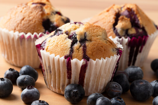 Close Up Homemade Blueberry Muffins with Blueberry Juice Dripping Down Paper Cases
