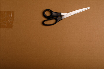Scissors on a cardboard background, perfect for use in office and crafting. Tools and materials for cutting and packagin