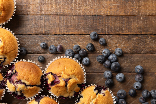 Homemade Blueberry Muffins and Fresh Blueberries on Dark Rustic Wooden Table with Copy Space