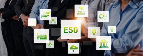 A diverse group of business professionals stands united, showcasing various icons symbolizing environmental, social, and governance concepts crucial for sustainable practices. Trope © InfiniteFlow