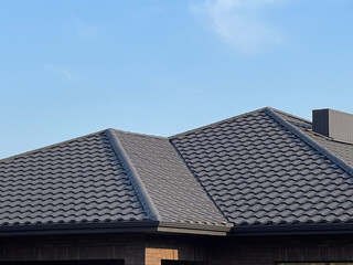 Fototapeta premium Roof and Tiles Shown Against Clear Sky, Illustrating the Design and Structure of a Building's Upper Section in Daylight