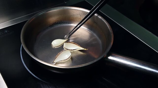 Cooking process of sliced onions in frying pan on induction cooktop