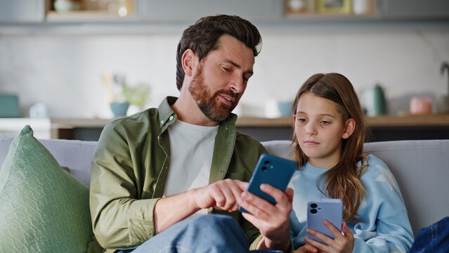 Father teenager looking mobile phones scrolling news feed at sofa closeup.