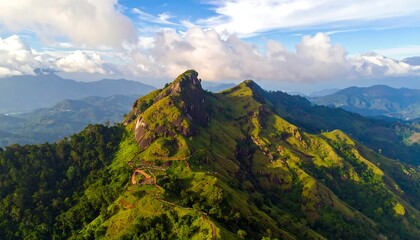 Verdant mountain peak, winding trails under blue sky, and wispy clouds in a panoramic landscape