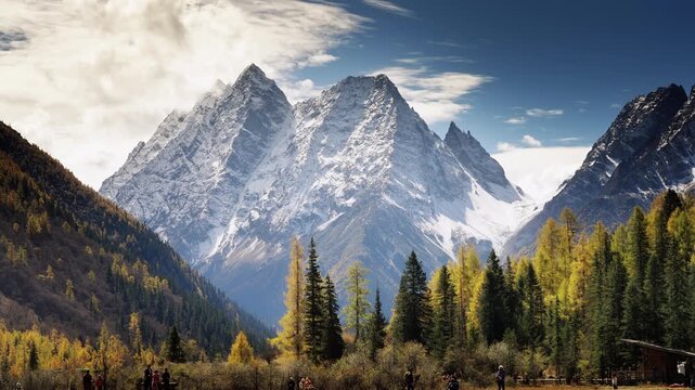 Snow-Capped Mountain Peaks with Autumn Forest Valley