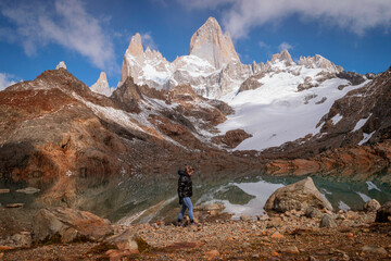 Fototapeta premium Girl walking between the mountains. Laguna de los tres and Fitz Roy