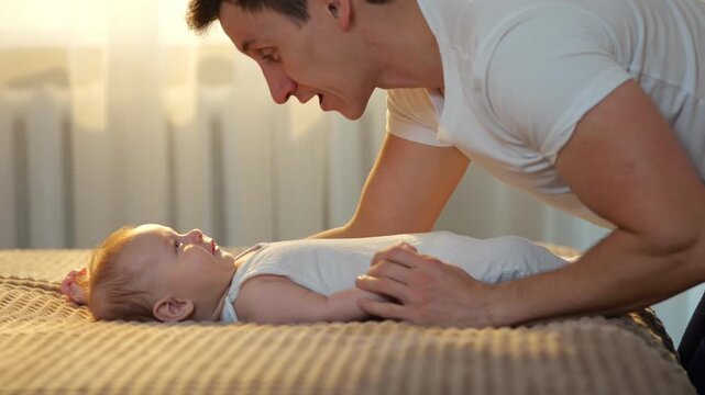 Joyful Family Time With Infant And Dad. Father And Child Share Cheerful Moments During Morning Play. Cheerful Family Begins Their Day With Playful Interactions Between Father And Adorable Baby
