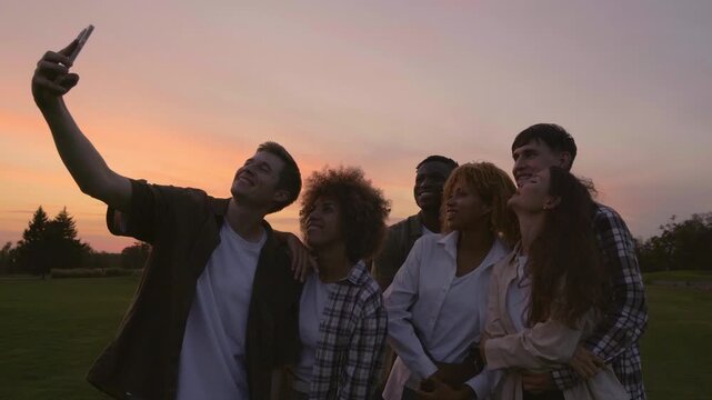 Group of six multiracial friends at the park together, embracing and taking selfies in partying on the at sunset sky, Teamwork concept 4K UHD B-Roll footage