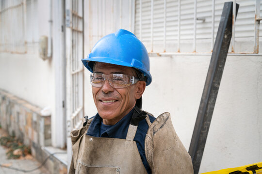 Smiling construction worker wearing hard hat and safety glasses