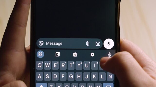 Close-up of hands typing a French apology "Pardon me :(" on a smartphone. Concept of regret, politeness, and digital communication in a dark-themed interface.