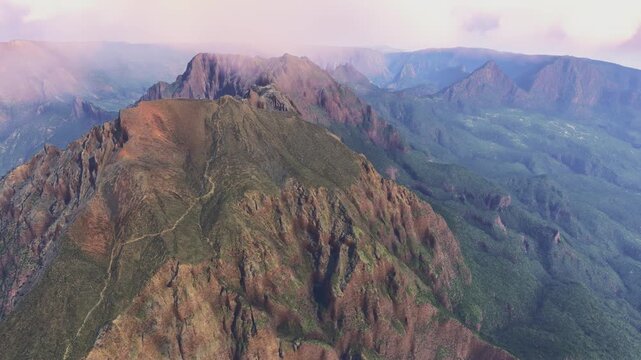 Side aerial drone shot at sunrise of Piton des Neiges Island. Reunion