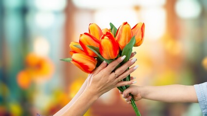 Happy women's day. Child congratulating mom with flowers.