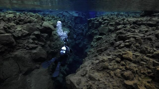 Professional diver exploring the Silfra fissure between tectonic plates in Thingvellir National Park