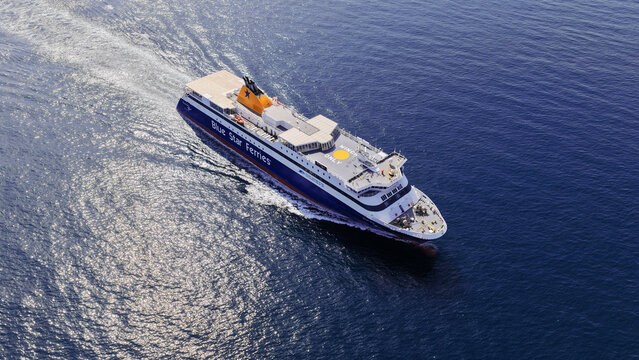 Aerial drone photo of Blue Star Paros passenger ferry cruising near Mykonos island, Cyclades, Greece