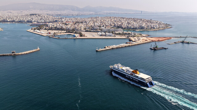Aerial drone tracking photo of Blue Star Paros passenger ferry reaching destination - busy port of Piraeus