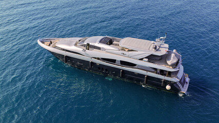 Aerial drone photo of luxury yacht with wooden deck anchored in Aegean island deep blue bay © aerial-drone