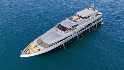 Aerial drone photo of luxury yacht with wooden deck anchored in Aegean island deep blue bay © aerial-drone