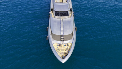Aerial drone photo of luxury yacht with wooden deck anchored in Aegean island deep blue bay © aerial-drone