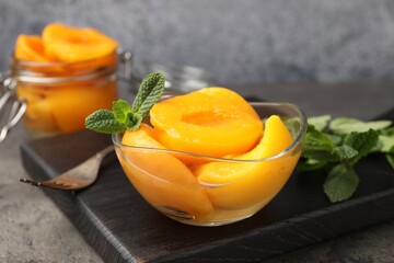 Pickled peaches and mint leaves on grey table, closeup © New Africa