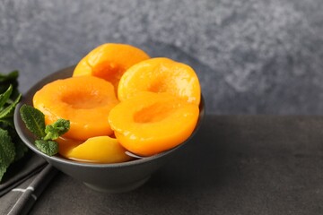 Pickled peaches and mint leaves on grey table, closeup. Space for text © New Africa