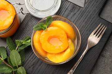 Pickled peaches and mint leaves on grey table, flat lay © New Africa