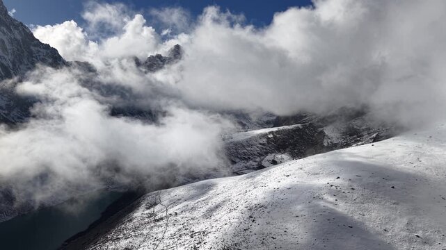 Fast-moving clouds with snowy ridges emerging in Khumbu valley in Himalayas