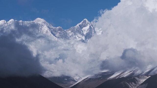 Nuptse, Everest and Lhotse piercing dramatic cloud layers with blue sky, Nepal