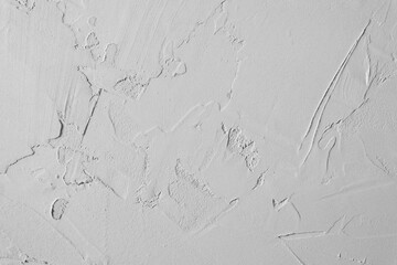 Rough gray plaster wall texture featuring uneven surface patterns and unique visible trowel marks © muse studio