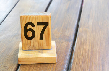 Wooden priority number 67 on a plank tab