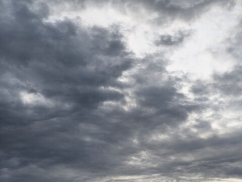 Dramatic dark storm clouds fill the sky, creating a moody and heavy overcast atmosphere. This textured gray cloudscape captures a pre-storm weather scene, perfect for dramatic nature backgrounds