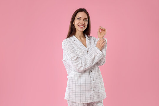 Beautiful woman in stylish pajamas on pink background