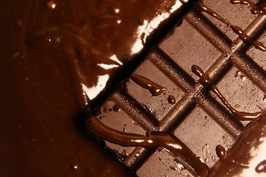 close up of chocolate bar on top of melted chocolate