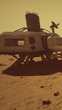 A habitat sits on the rocky Martian surface under a pale sky. Dust and stones are scattered around. The scene shows the structure prepared for human exploration and research on Mars.