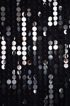 Abstract background with flickering and glittering silver metallic particles or sequins on the wall
