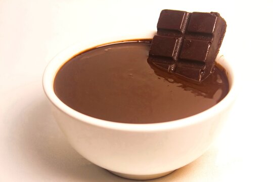 bowl of hot chocolate with chocolate bar isolated on white background