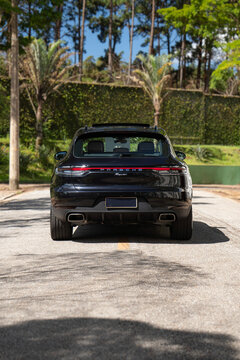 Black Porsche Macan rear view outdoors, Luxury compact SUV parked in park
